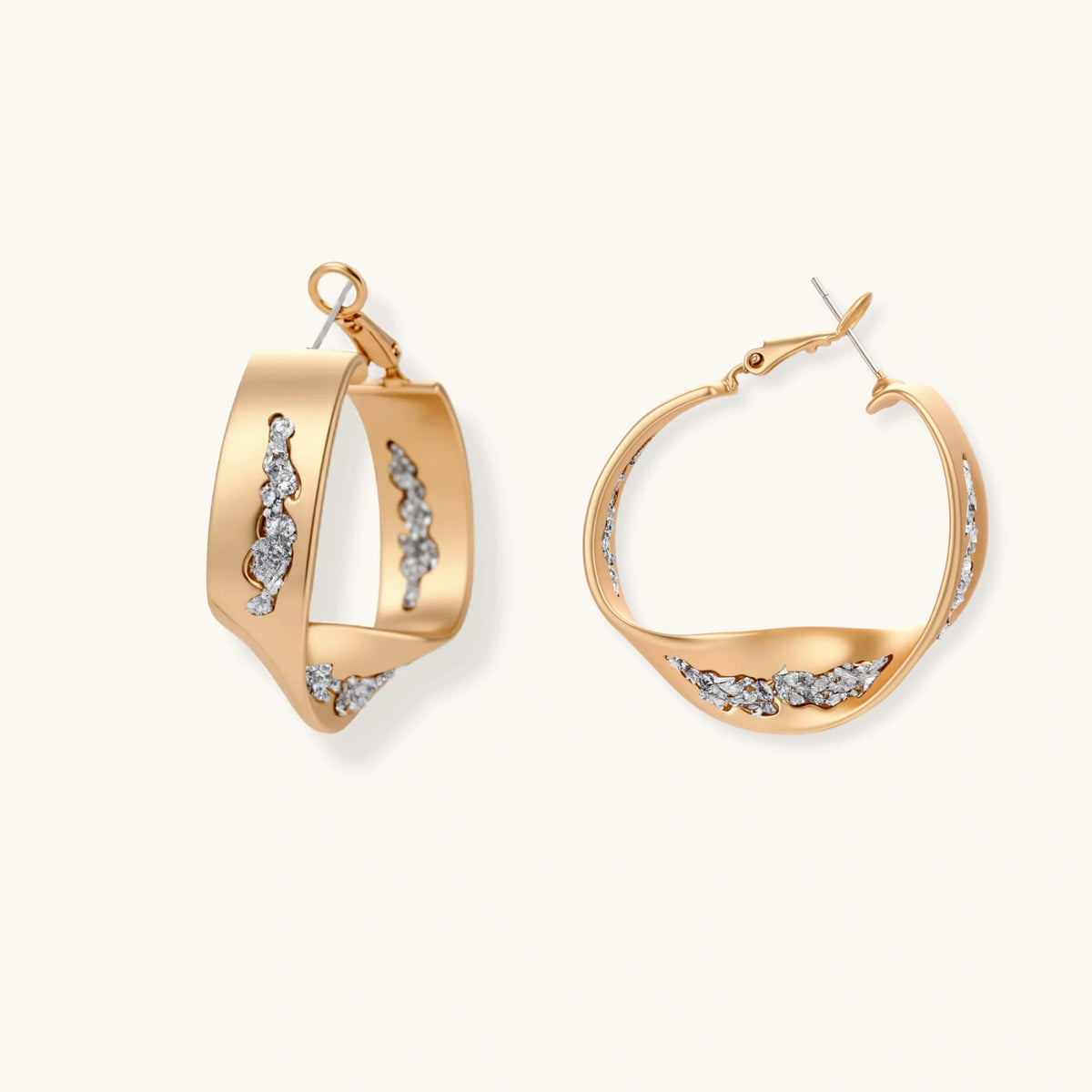 Sculptural wavy hoop earrings with crystal details and organic curved silhouette in gold and silver variants