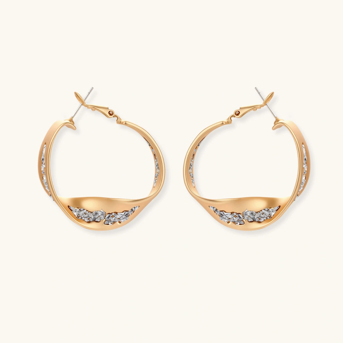 Sculptural wavy hoop earrings with crystal details and organic curved silhouette in gold and silver variants