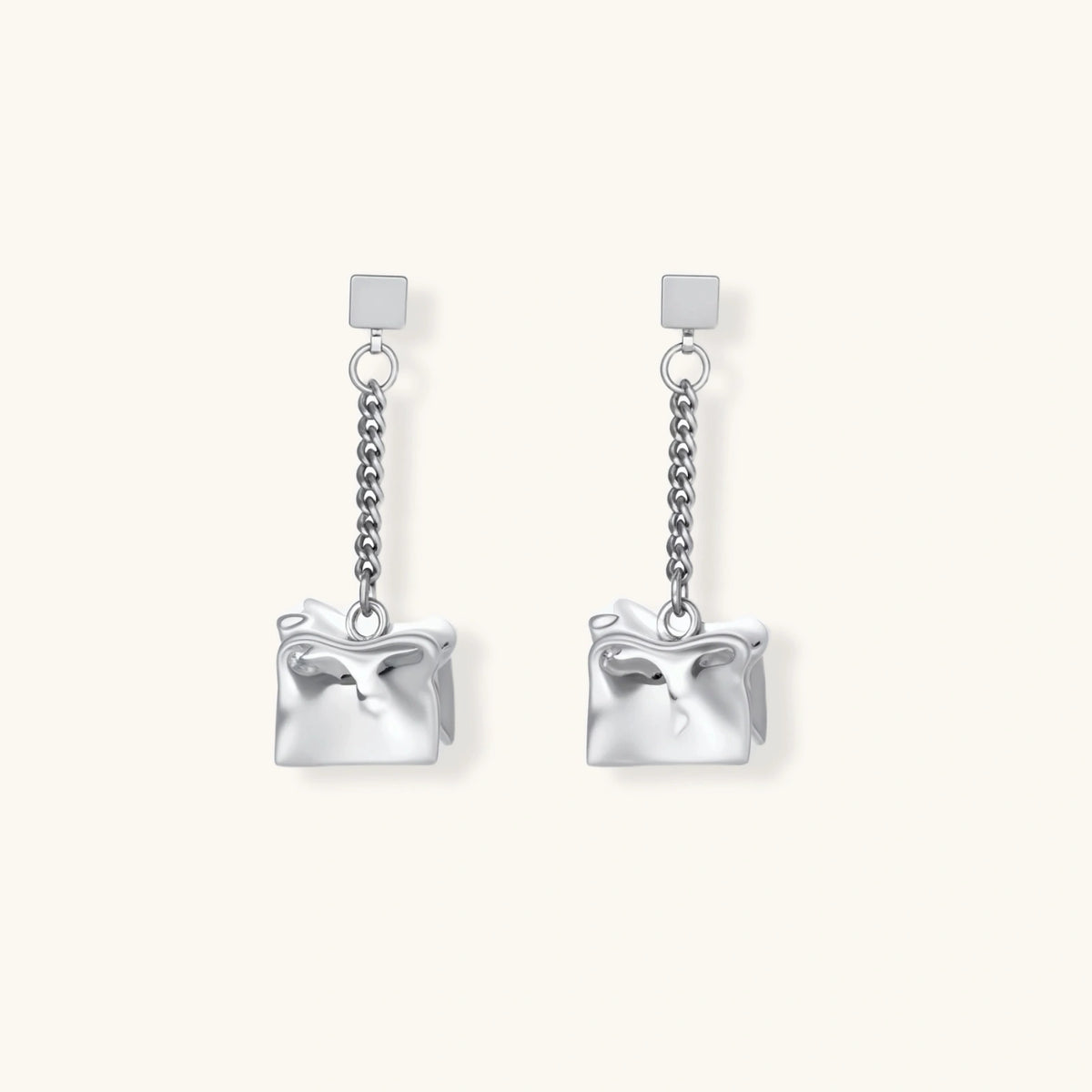 Modern silver dangle earrings with geometric cube pendants and chain design on minimalist background.