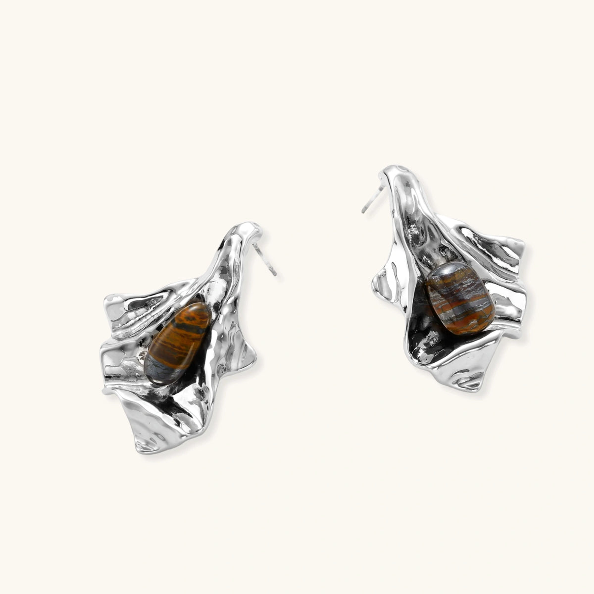 Silver sculptural earrings with flowing molten forms and amber gemstones, featuring 925 silver posts on white background.